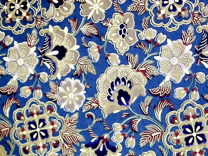Pu&ograve; includere: Un tessuto blu con un motivo floreale. I fiori sono in tonalit&agrave; di bianco, beige e marrone. Le foglie sono in tonalit&agrave; di rosso e marrone.