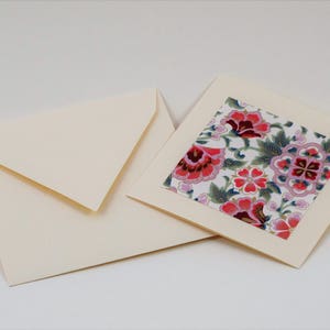 Puede incluir: Una tarjeta de marfil en blanco con un dise&ntilde;o floral en el interior. El dise&ntilde;o floral es rosa, rojo y verde sobre un fondo blanco.