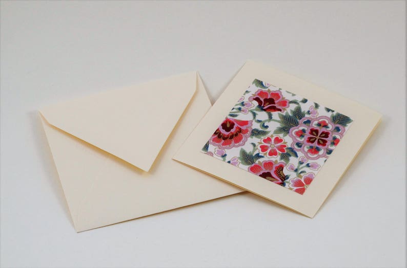 Puede incluir: Una tarjeta de marfil en blanco con un dise&ntilde;o floral en el interior. El dise&ntilde;o floral es rosa, rojo y verde sobre un fondo blanco.