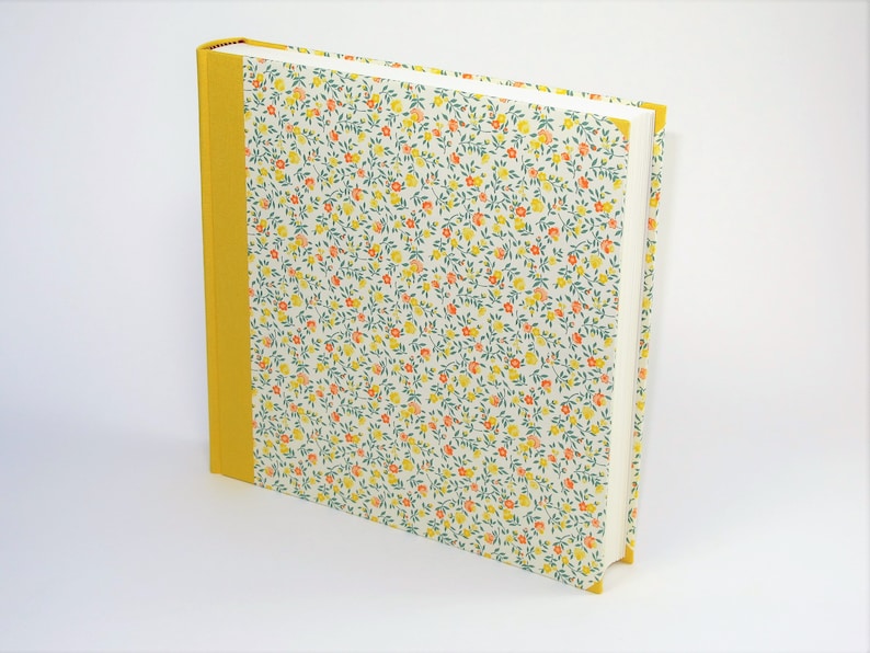 Puede incluir: Un &aacute;lbum de fotos de tapa dura con un patr&oacute;n floral amarillo y una columna vertebral amarilla.