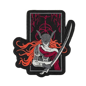 Puede incluir: Parche bordado que representa a un guerrero con casco, pelo naranja y una espada. El diseño incluye un fondo negro con detalles rojos y una figura estilizada. El parche tiene un borde negro.