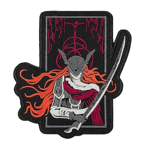 May include: Embroidered patch featuring a warrior figure with a helmet, flowing orange hair, and a sword. The design includes a black background with a red and gray border. The warrior is depicted in shades of gray, white, and red.