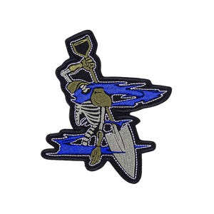May include: Embroidered patch featuring a skeleton figure with a shovel, set against a blue and black background. The skeleton is depicted in a digging pose, with a gray shovel. The patch has a black border.