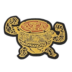 Könnte beinhalten: Gestickter Aufnäher mit einem stilisierten Topf mit flexierenden Armen. Der Aufnäher hat einen schwarzen Rand, einen goldfarbenen Topf mit komplizierten Designs und einen roten Innenraum. Die Arme sind ebenfalls goldfarben mit schwarzen Details.