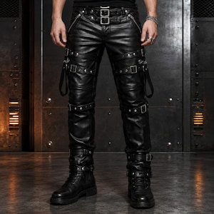 May include: Black pants featuring a smooth finish, multiple horizontal straps with silver-toned metal buckles, and vertical zippers near the waist. The design includes reinforced stitching, metallic studs, and adjustable leg straps that wrap around.