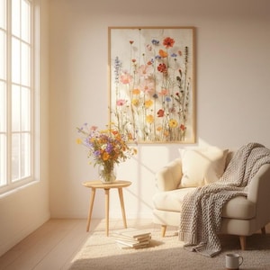 Framed wildflower art print hanging in a cozy, sunlit reading nook with a Scandi-Hygge aesthetic. Featuring a comfortable armchair with a chunky knit throw, a wooden side table with a fresh bouquet of wildflowers, and soft morning sunlight. Perfect botanical wall decor for a relaxing, modern home interior.