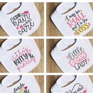 Puede incluir: Seis baberos blancos para bebé con diferentes lemas impresos en ellos. Los lemas incluyen "Crib hair don't care", "Itty Bitty & Pretty", "Made with love and a little science", "I may be small but I'm the boss", "Little boss lady", y "You are so loved".