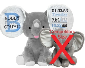 Op de afbeelding: Twee grijze pluche olifanten. De grotere olifant heeft een wit oor met de tekst "BOBBY INDIGO GRUHIN" en een blauwe letter "B". De kleinere olifant heeft een wit oor met de tekst "01.03.23 Dinsdag 7.54 LBS 19.5 INCHES 10:22 AM" en de tekst "Competitors Size" in rood.