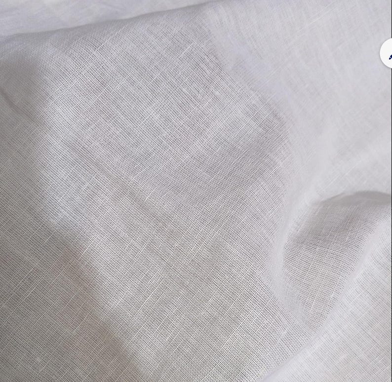 Pode incluir: Uma pe&ccedil;a de tecido branco com uma textura tecida vis&iacute;vel. O material apresenta um padr&atilde;o de trama cruzada distinto criado pelo entrela&ccedil;amento de fios horizontais e verticais, resultando numa apar&ecirc;ncia semitransparente com dobras e vincos naturais.