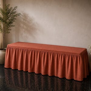 May include: A rectangular bench cover in a solid burnt orange color. The cover features a flat top surface and a gathered, pleated skirt that hangs down from the edges, providing a full-length drape around the base of the bench structure.