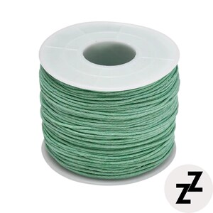 May include: A spool of green waxed cord. The cord is tightly wound around a white plastic spool. The cord is a muted green color. The spool has a central hole and a circular base. The image is on a white background.