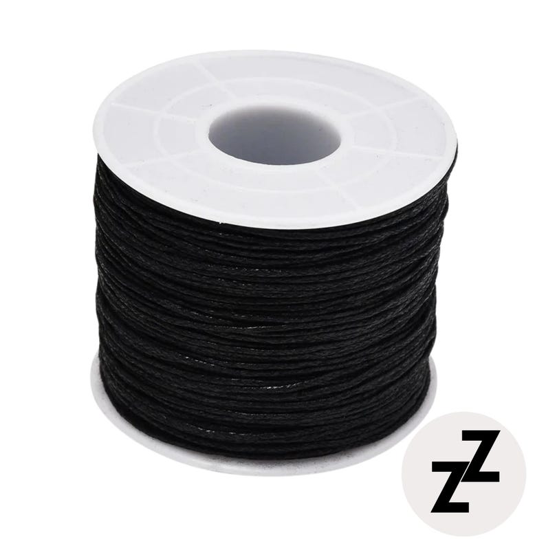 May include: A spool of black waxed cord, tightly wound around a white plastic core. The cord appears smooth and durable, suitable for various crafting projects. A white circular logo with the letters "ZZ" is in the lower right corner.