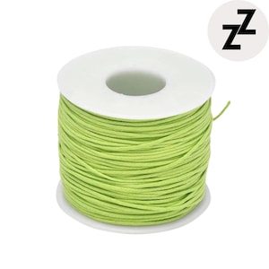May include: A spool of light green cord wound around a white plastic core. The cord is tightly packed, and the spool is set against a white background. A logo with the letter "Z" is in the upper right corner.