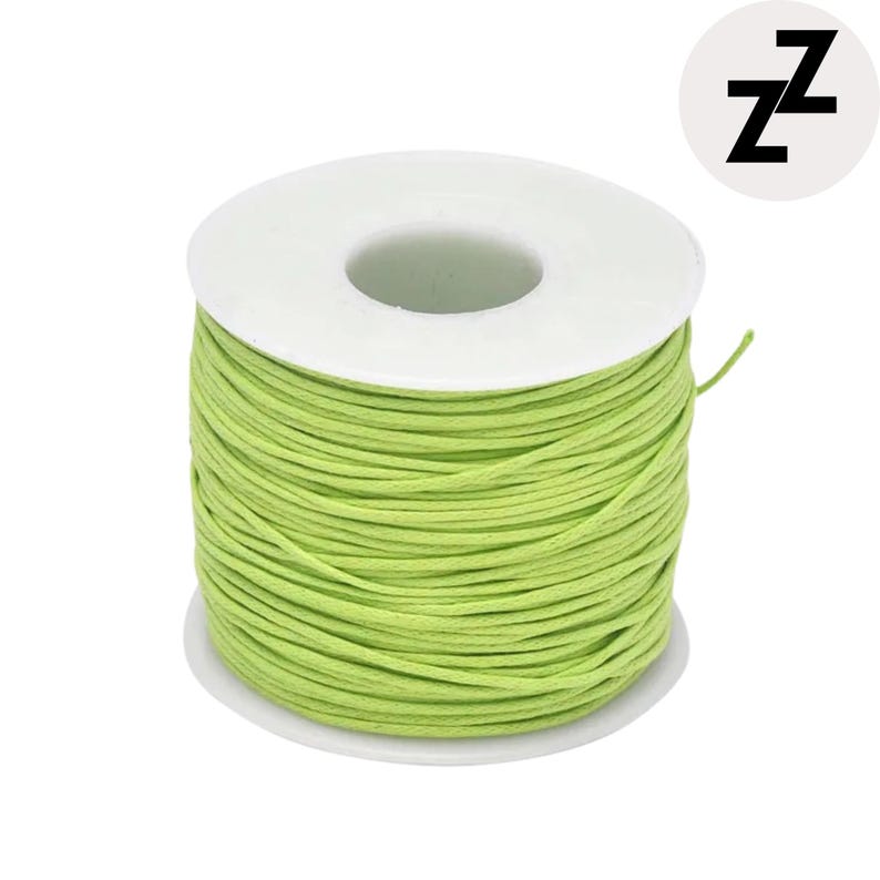 May include: A spool of light green cord wound around a white plastic core. The cord is tightly packed, and the spool is set against a white background. A logo with the letter "Z" is in the upper right corner.