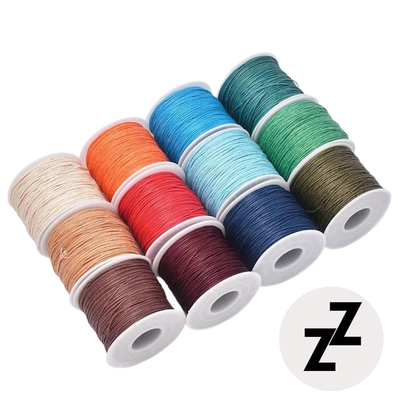 May include: A collection of colorful spools of waxed thread in various shades, including beige, orange, red, blue, and green. The spools are arranged in a diagonal pattern, showcasing the different colors. A white circle with the letter "Z" is in the bottom right corner.