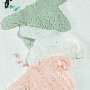 Könnte beinhalten: Drei gestrickte Baby-Cardigans in Pastellfarben: Mintgrün, Weiß und Hellrosa. Die Cardigans haben Knopfverschlüsse und dekorative Strickmuster. Die Größen reichen von 36 bis 51 cm (14 bis 20 Zoll).