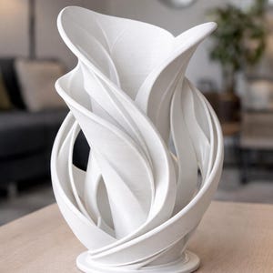 Peut inclure: Un vase décoratif blanc et abstrait avec un motif floral tourbillonnant. Le vase a une base large et un sommet haut et ouvert, avec des éléments incurvés en forme de feuilles. Le vase est fait d'un matériau solide et opaque.