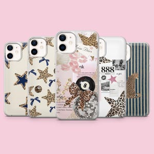 May include: A collection of five phone cases with various designs. The cases feature patterns like leopard print stars, blue bows, and text. One case has a disco ball and an eight ball. The cases are on a pink background.