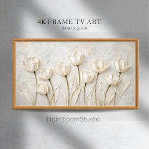 Puede incluir: Una obra de arte enmarcada con flores de tulipanes blancos con pétalos texturizados y tallos verdes sobre un fondo claro. El marco es de color marrón claro. El texto "4K FRAME TV ART" y "3840 x 2160" son visibles en la parte superior. El texto "NoirBloomStudio" está en la parte inferior.