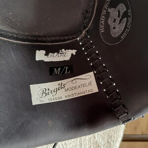 May include: Dark brown leather hat with stitched seams and a label that reads "Bogie" and "M/L". A circular logo with the text "Head 'n Home Santa Cruz, CA" is also visible.