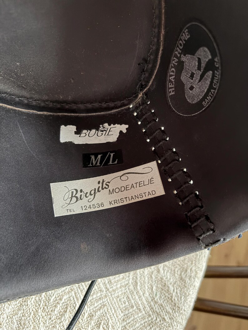 May include: Dark brown leather hat with stitched seams and a label that reads "Bogie" and "M/L". A circular logo with the text "Head 'n Home Santa Cruz, CA" is also visible.