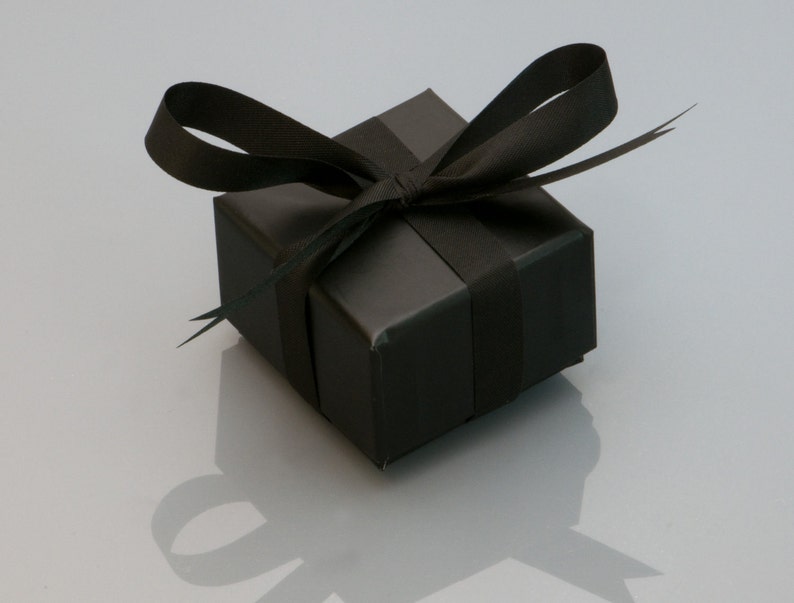 May include: A black gift box with a black satin ribbon tied in a bow.