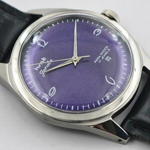 May include: A vintage wristwatch with a purple dial and silver hands. The watch face has white numerals and the words "Para Shock 17 Jewels". The watch has a silver case and a black leather band.