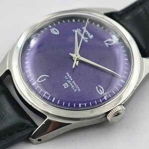 May include: A vintage wristwatch with a silver-toned case and a deep purple dial. The watch features silver hands and hour markers, with the text "Para Shock 17 Jewels". The watch has a black leather band.