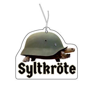 Könnte beinhalten: Ein hängender Lufterfrischer mit einer Schildkröte, die einen grünen Militärhelm als Panzer trägt. Die Schildkröte ist im Profil nach rechts abgebildet. Unter der Schildkröte steht das Wort Syltkröte in einer fetten, schwarzen Serifenschrift.