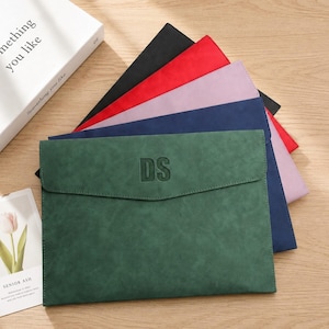 May include: A collection of rectangular document folders in various colors including dark green, navy blue, light purple, red, and black. The front-most dark green folder features the embossed letters DS centered on the flap closure.