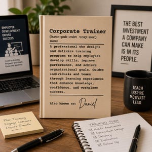 May include: A beige rectangular sign featuring a dictionary-style definition of Corporate Trainer in black text. The text includes a phonetic pronunciation, a noun definition, and the handwritten name Daniel under the heading Also known as.