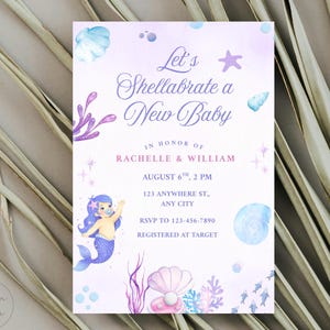May include: A baby shower invitation with a mermaid theme. The invitation features a watercolor design in shades of purple and blue, with a mermaid illustration, seashells, and the text "Let's Shellabrate a New Baby."