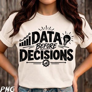 Op de afbeelding: Een crèmekleurig T-shirt met korte mouwen en zwarte grafische tekst met de tekst "DATA BEFORE DECISIONS". Het ontwerp bevat een lijngrafiekpictogram, een gloeilamp en een tandwielpictogram met een staafdiagram, allemaal gedrukt in verweerde zwarte inkt.