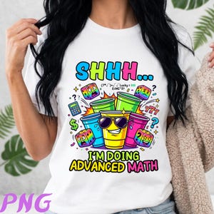 May include: A white t-shirt featuring a colorful graphic of plastic party cups and dice with faces. The text reads SHHH... I'M DOING ADVANCED MATH along with mathematical symbols and numbers. The design includes a calculator, dollar sign, and question marks.