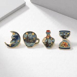 May include: Set of four enamel pins featuring artwork inspired by Van Gogh's "Starry Night." Designs include a crescent moon, a teacup, a bottle, and an hourglass. Each pin has a gold-colored outline and a blue and yellow color scheme.