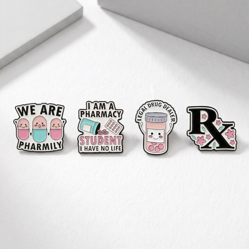 Op de afbeelding: Set van vier emaille pins met apotheek-thema ontwerpen. E&eacute;n pin leest "WE ARE PHARMILY", een andere zegt "I AM A PHARMACY STUDENT I HAVE NO LIFE", een derde zegt "LEGAL DRUG DEALER", en de laatste heeft een Rx-symbool met bloemen.