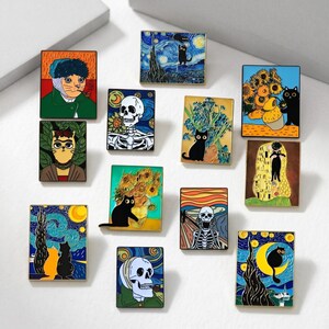 May include: A collection of rectangular enamel pins featuring famous art pieces with a cat theme. The pins depict artwork like Van Gogh's Starry Night and sunflowers, with cats replacing the original subjects. The color palette includes blues, yellows, and blacks.