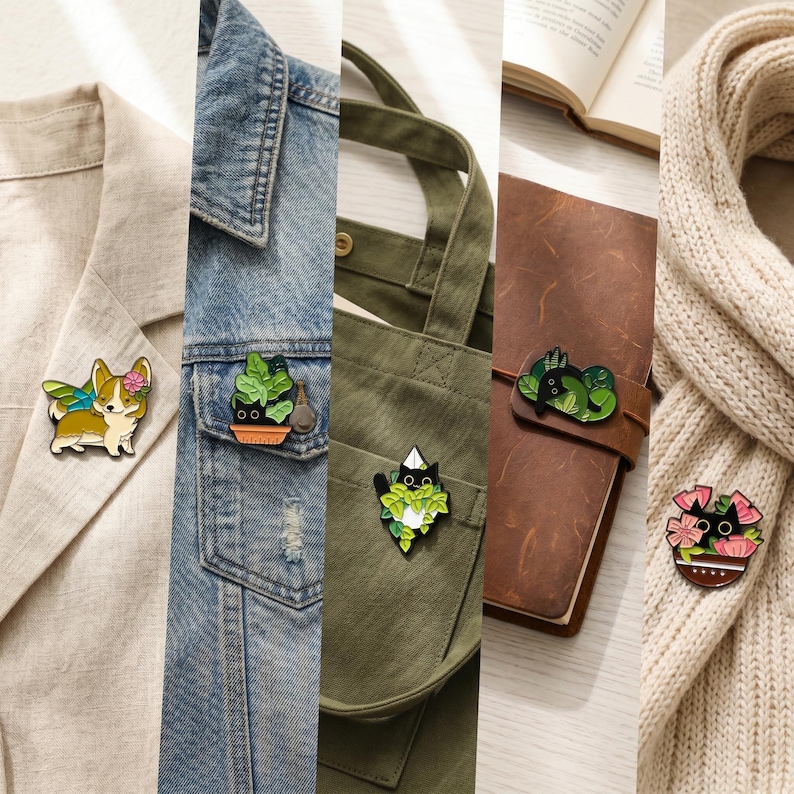 Op de afbeelding: Een verzameling emaille pins met diverse ontwerpen. Bevat een corgi met vleugels en een bloem, een potplant, een zwarte kat in een plant, een kat die in bladeren slaapt en een kat in een bloempot. De pins zijn bevestigd aan kleding en accessoires.