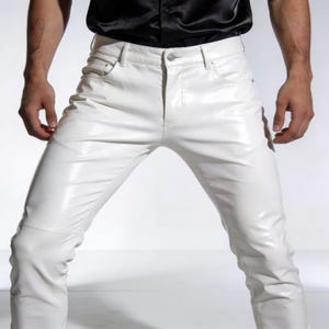 May include: White, form-fitting pants with a shiny, leather-like appearance. The pants have a classic five-pocket design and a button closure. The knees have a subtle seam detail. The pants are part of a fashion apparel collection.