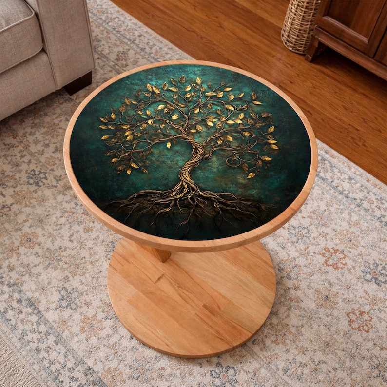 May include: A round wooden side table with a teal and gold tree of life design on the tabletop. The tree features gold leaves and roots against a teal background. The table has a light wood base and a round pedestal.