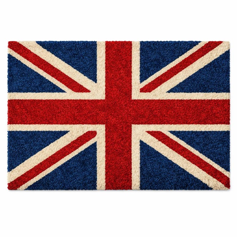 Puede incluir: Una alfombra rectangular que muestra la Union Jack, la bandera del Reino Unido. La alfombra tiene un fondo azul con una cruz roja y rayas diagonales, y detalles en crema. La alfombra est&aacute; hecha de un material texturizado.