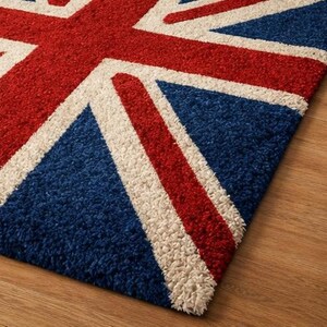 Puede incluir: Una alfombra rectangular con el dise&ntilde;o de la bandera brit&aacute;nica, la Union Jack. La alfombra tiene un fondo azul con rayas rojas y blancas, con una textura visible. Colocada sobre un suelo de madera.