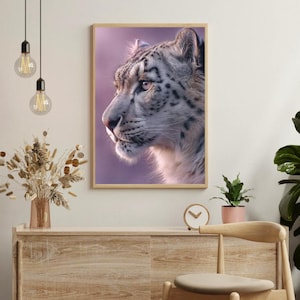 May include: A framed print featuring a snow leopard in profile, set against a soft purple backdrop. The big cat's fur is a mix of white and grey with black spots. The artwork is displayed above a wooden cabinet.