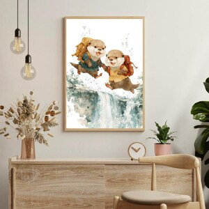 Könnte beinhalten: Gerahmter Aquarelldruck mit zwei Ottern mit Rucksäcken, die über einen Wasserfall springen. Die Otter sind in einem skurrilen Stil dargestellt und tragen kleine Outfits. Das Kunstwerk ist in einem hellen Holzrahmen präsentiert.
