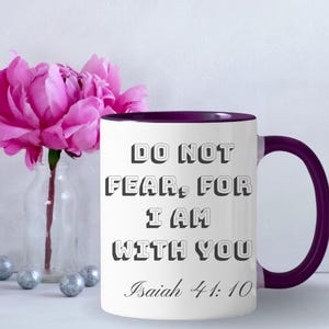 May include: A white ceramic mug with a dark purple interior and handle. The front features the black text "DO NOT FEAR, FOR I AM WITH YOU" in a bold, blocky font, followed by the script text "Isaiah 41:10" printed in a smaller size.