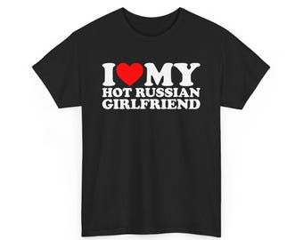 以下が含まれることがあります： 黒いTシャツ。白い文字で「I ♥ MY HOT RUSSIAN GIRLFRIEND」と書かれており、「love」の代わりに赤いハートマークが使われています。クルーネックのTシャツです。