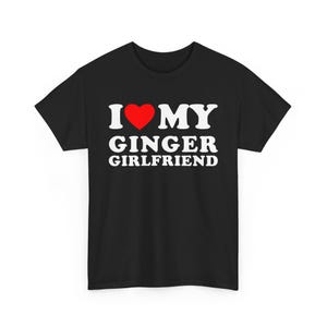 May include: Black t-shirt with the text "I ❤️ MY GINGER GIRLFRIEND" in white, with a red heart replacing the word "love". The shirt is a classic crew neck style.