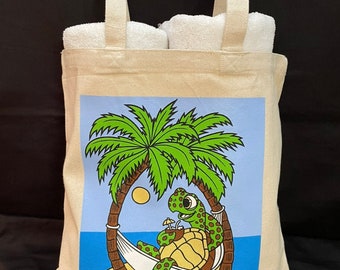 May include: A white canvas tote bag with a cartoon illustration of a turtle relaxing in a hammock under a palm tree. The text "LOUISIANASHIRTS.COM" is printed on the bag.