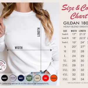 Op de afbeelding: Een witte Gildan 18000 heavy blend sweatshirt met een maat- en kleurentabel. De tabel geeft de afmetingen in inches weer. Beschikbare kleuren zijn wit, zwart, marine en rood. Het sweatshirt is verkrijgbaar in diverse maten.