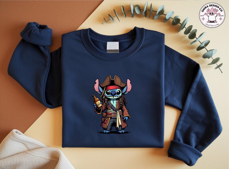 May include: Navy blue sweatshirt featuring a cartoon illustration of Stitch dressed as a pirate, complete with a brown hat, coat, and a bottle. The design is centered on the front of the crewneck sweatshirt.